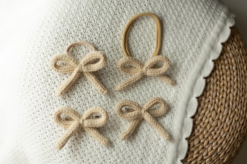 Pode incluir: Quatro la&ccedil;os de cabelo de malha bege com el&aacute;sticos. Os la&ccedil;os est&atilde;o dispostos sobre um cobertor de croch&ecirc; branco.
