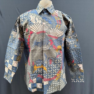 May include: A long-sleeved shirt with a blue, red, and gold batik pattern. The shirt has a collared neckline and a button-up front.