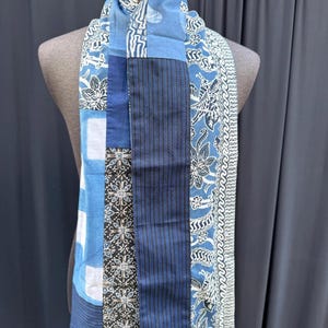 Peut inclure: Une écharpe en patchwork bleu et blanc avec une variété de motifs, y compris des motifs floraux et géométriques.