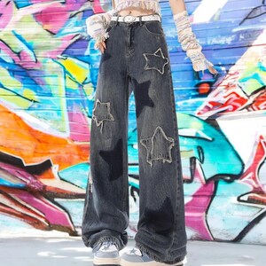 May include: A pair of dark blue denim jeans with large star-shaped patches. The jeans have a wide leg and a high waist.
