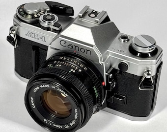 Stary aparat fotograficzny Canon AE-1 35 mm z obiektywem stałoogniskowym FD 50 mm f/1.8