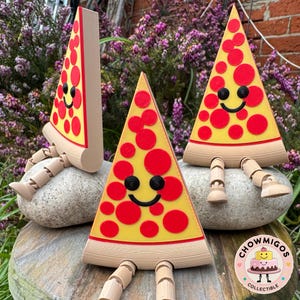 Könnte beinhalten: Drei skurrile Pizza-Scheiben-Figuren mit lächelnden Gesichtern und roten Pepperoni auf gelbem Grund. Die Pizzastücke haben Holzbeine und sitzen auf Steinen. Das Chowmigos Collectible-Logo befindet sich unten rechts.