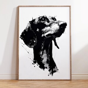 Puede incluir: Ilustración en tinta negra y blanca de la cabeza de un perro, enmarcada en madera clara. La obra presenta trazos audaces y salpicaduras, creando un retrato dinámico. El perro está representado de perfil, mirando hacia arriba.