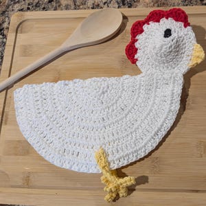 May include: White crocheted chicken dishcloth with red comb, yellow beak, and yellow feet.