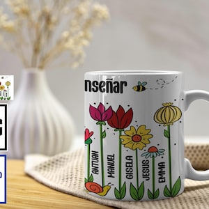 Op de afbeelding: Witte keramische mok met kleurrijke bloemenillustraties en het woord "enseñar". De mok heeft namen als Antuan, Manuel en Gisela. Een bij vliegt in de buurt van de bovenkant. Een digitale download-afbeelding is zichtbaar.