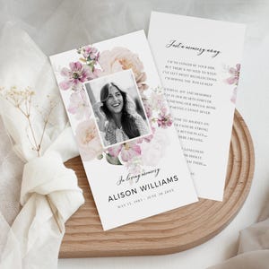 Puede incluir: Una tarjeta conmemorativa con una foto de una persona sonriente, rodeada de acentos florales rosas y melocotón. La tarjeta incluye el texto "In loving memory" y el nombre "Alison Williams" con fechas. Una segunda tarjeta muestra un poema.