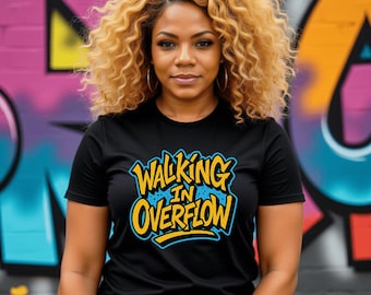 May include: A black t-shirt with the words "Walking in Overflow" in yellow and blue lettering. The person in the image is wearing gold hoop earrings and has curly blonde hair. The background is a colorful graffiti wall.