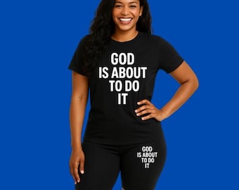May include: Black athletic wear set with a short-sleeved t-shirt and biker shorts. The t-shirt and shorts both feature the text "God is about to do it" in white.
