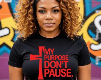 May include: Black t-shirt with the text "MY PURPOSE DON'T PAUSE" in red, featuring a cross design. The woman in the image is wearing gold hoop earrings and has curly hair.