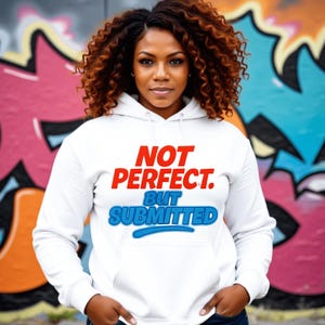 Puede incluir: Sudadera con capucha blanca con el texto "NOT PERFECT. BUT SUBMITTED" en rojo y azul. La sudadera tiene una capucha con cordón y un bolsillo delantero. El fondo presenta arte de graffiti colorido.