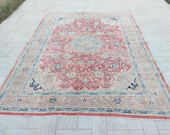 May include: A large, rectangular rug with an intricate floral pattern in shades of red, blue, and cream. The rug features a central medallion design and a detailed border, suitable for a living room or bedroom.
