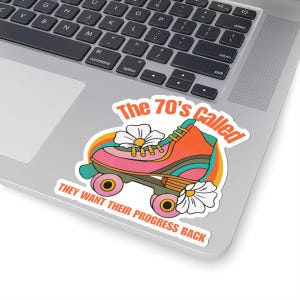 Può includere: Un adesivo con un design di pattino a rotelle retrò e il testo "The 70's Called THEY WANT THEIR PROGRESS BACK." Il pattino a rotelle è rosa e arancione con accenti arcobaleno e fiori.