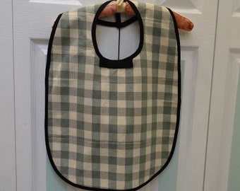 UNISEX ADULT BIB, green and lt. beige checkerboard  pattern ,white felt lined,17" by 24",neck fastener ,black bias trim