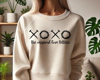 May include: A cream-colored sweatshirt with a black graphic design featuring a crown of thorns and nails, with the text "XOXO the original love letters".