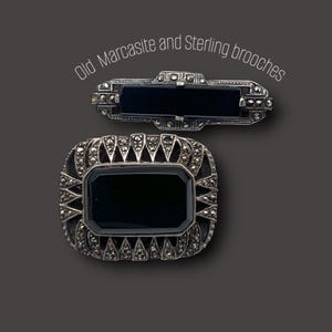 Könnte beinhalten: Zwei antike Broschen mit dem Text "Old Marcasite and Sterling brooches". Die Broschen sind silberfarben mit schwarzen rechteckigen Mittelsteinen. Eine ist rechteckig, die andere oval.