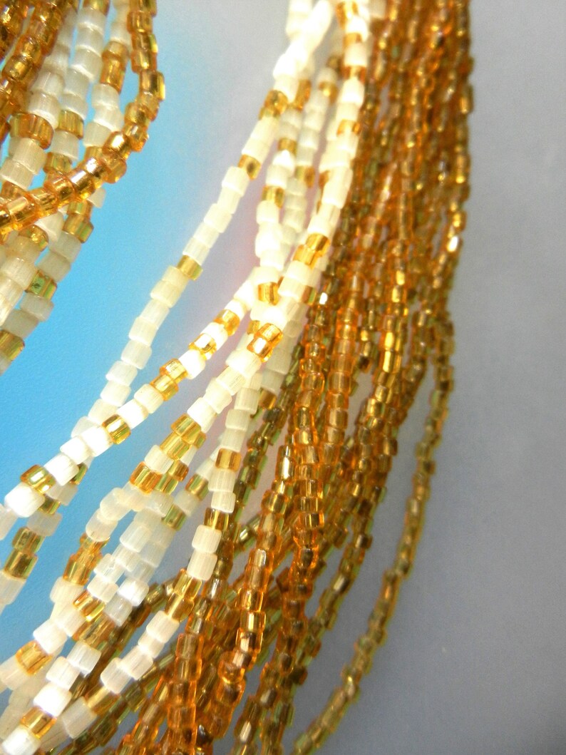 Art.3075 Appealing multi strands old Venetian necklace made of amber and milky white of small seed glass beads