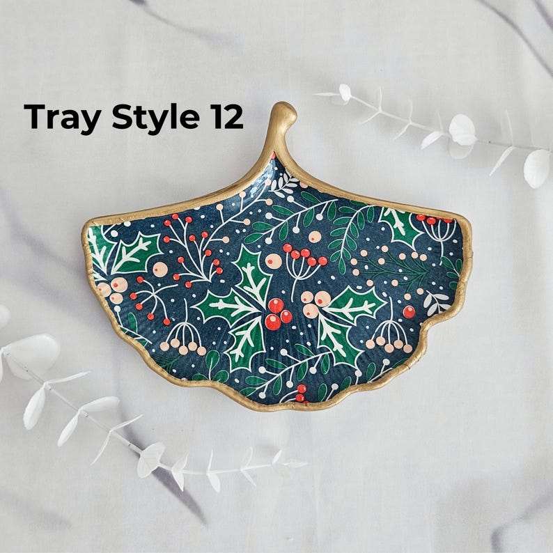 May include: A decorative tray in a ginkgo leaf shape, featuring a dark blue background with a festive holly and berry pattern. The tray has a gold-colored rim and the text "Tray Style 12" in the upper left corner.