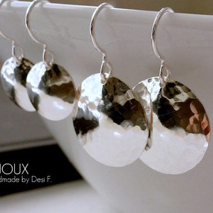 May include: Three pairs of silver hammered disc earrings with a simple hook closure. The earrings are a light silver color and have a textured, hammered finish.