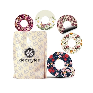 May include: A selection of floral-patterned adhesive covers from Dexstyles. The designs include daisies, roses, and other flowers in red, pink, and purple hues. The package, featuring the Dexstyles logo and text, is also visible.