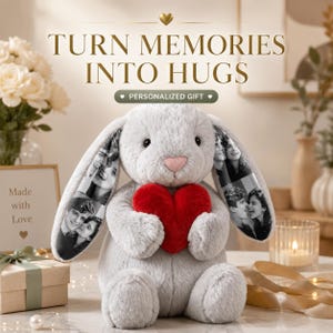 May include: A plush grey rabbit stuffed animal with long ears featuring black and white printed photographs. The rabbit has a pink nose and holds a bright red plush heart. Text above reads: TURN MEMORIES INTO HUGS and PERSONALIZED GIFT.
