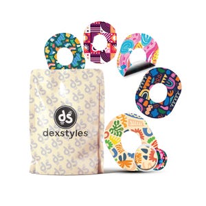 Könnte beinhalten: Eine Packung Dexstyles-Produkte mit mehreren bunten, gemusterten Aufklebern. Die Aufkleber haben verschiedene Designs, darunter abstrakte Formen und Muster. Die Verpackung ist beige mit dem Dexstyles-Logo und -Text.