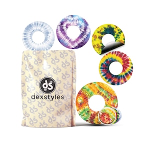Könnte beinhalten: Eine Packung Tie-Dye-Aufkleber mit verschiedenen farbenfrohen Designs. Die Aufkleber sind kreisförmig mit einem Loch in der Mitte. Das Paket trägt das "dexstyles"-Logo. Die Aufkleber zeigen blaue, violette, gelbe, rote und orangefarbene Tie-Dye-Muster.