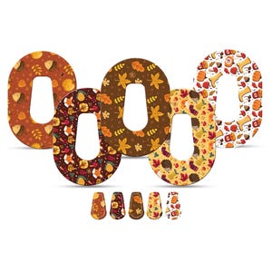 May include: A collection of decorative letter "O" shapes with autumn-themed patterns. The designs include leaves, acorns, and other fall elements in shades of brown, orange, and yellow. Small, matching decorative shapes are at the bottom.