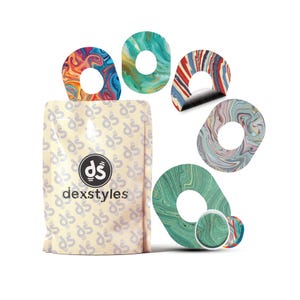May include: A selection of Dexstyles stickers with swirling patterns in shades of blue, green, red, and pink. The stickers are displayed with a beige package featuring the "ds" logo. The package has the text "dexstyles".