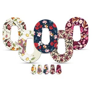 Puede incluir: Cinco cubiertas de dispositivos médicos con estampados florales variados. Los patrones incluyen flores, hojas y vides en colores como rojo, blanco, morado y verde. La imagen también muestra cinco cubiertas más pequeñas a juego.