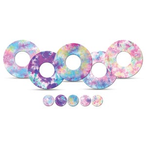 Könnte beinhalten: Eine Sammlung von Kreisen mit Batikmuster in verschiedenen Pastellfarben, darunter Rosa, Lila, Blau und Gelb. Kleinere passende Kreise werden darunter angezeigt. Das Design hat einen Aquarell-Effekt.