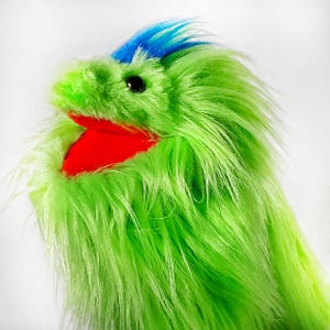 May include: A bright green fuzzy puppet with a red mouth and blue hair. The puppet is made of soft, plush material and has a friendly expression.