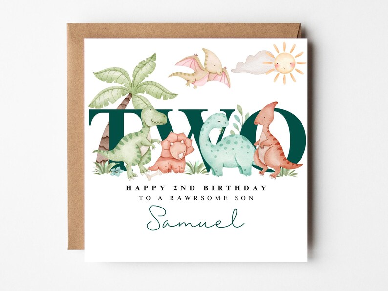 May include: A square birthday card featuring a dinosaur-themed illustration. The design includes the word "TWO" in dark green, dinosaurs, palm trees, and the text "HAPPY 2ND BIRTHDAY TO A RAWSOME SON" with a name in script.