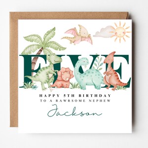 May include: A birthday card with a brown envelope. The card features the word "FIVE" in dark green, with watercolor dinosaurs and a sun illustration. Text reads "Happy 5th Birthday to a rawsome nephew" and a name.