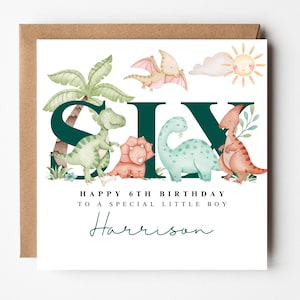 May include: A birthday card with a brown envelope, featuring the word "SIX" with dinosaur illustrations. The card says "Happy 6th Birthday to a special little boy" and includes the name "Harrison" in a script font.