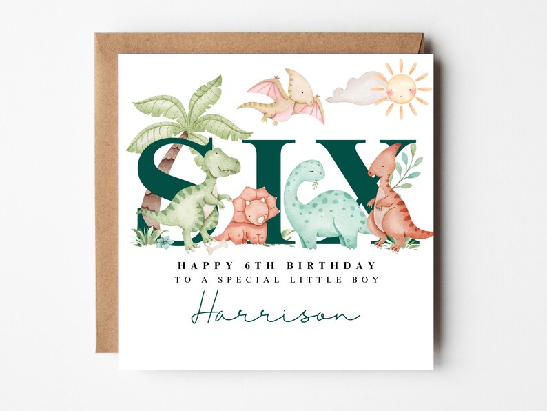 May include: A birthday card with a brown envelope, featuring the word "SIX" with dinosaur illustrations. The card says "Happy 6th Birthday to a special little boy" and includes the name "Harrison" in a script font.