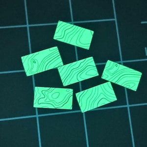 May include: Six rectangular pieces with a vibrant neon green glow and black topographic map line patterns. Each piece features unique, flowing contour lines that mimic geographical terrain maps, arranged in a scattered formation.