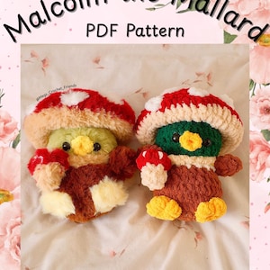 May include: Two crocheted duck plushies, each wearing a mushroom hat. One duck is green and yellow, the other is brown and yellow. The text "Malcolm the Mallard PDF Pattern" is at the top, with the Instagram handle @Megs_Crochet_Friends at the bottom.
