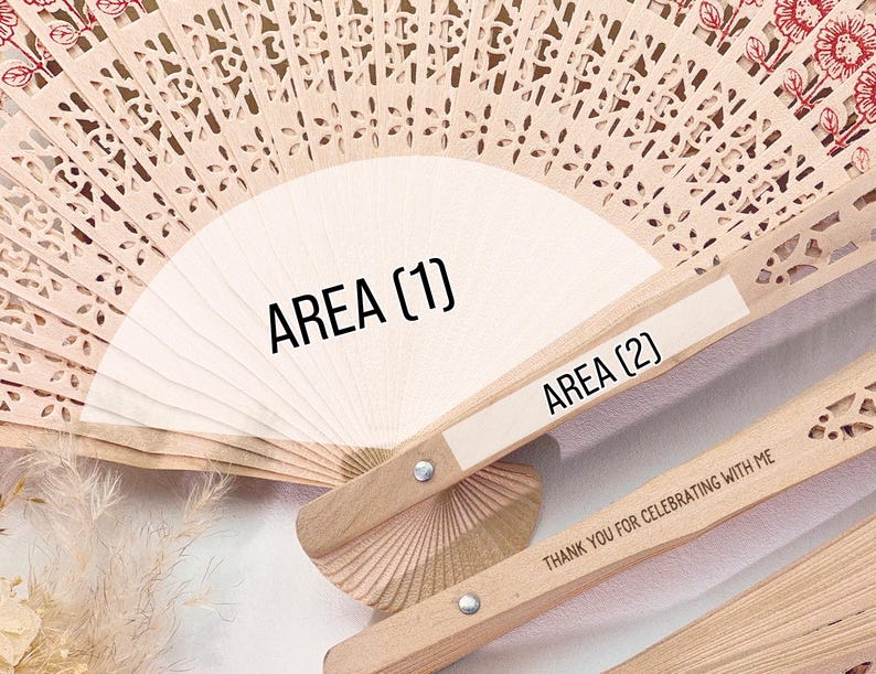May include: Wooden hand fans with intricate cut-out designs. The fans are light brown with a white area for text. The text on the fan reads "AREA (1)" and "AREA (2)". The fan's handle has the text "THANK YOU FOR CELEBRATING WITH ME".