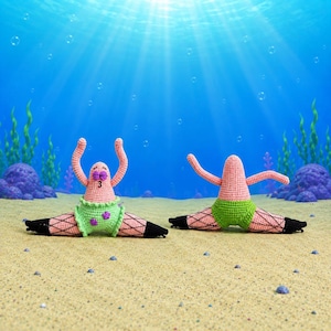 May include: Two crocheted starfish figures in a split pose. The figures are light pink with green shorts, purple flower accents, and black fishnet-style leg coverings. One figure has a facial expression with closed eyes and a small mouth.