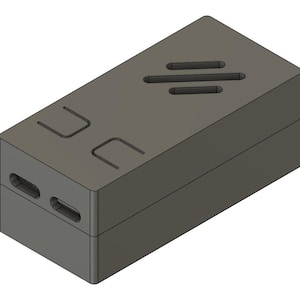 May include: A gray rectangular box with a slightly angled top. The top has three horizontal slots and two U-shaped cutouts. The sides have two oval openings. The box is a solid, geometric design.