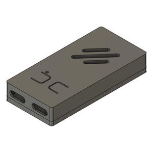 May include: A rectangular, gray device with rounded corners. It features two oval openings on one end and three horizontal slots on the top surface. The letters "JC" are etched on the side.