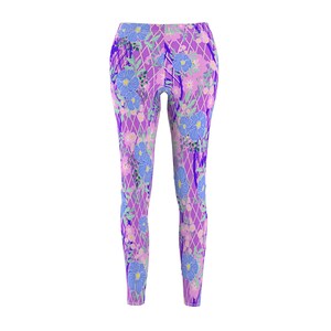 May include: Purple leggings with a floral pattern featuring blue flowers and pink accents. The leggings have a geometric pattern overlay.