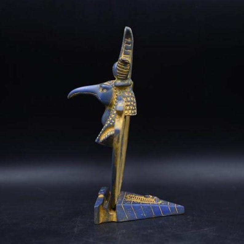 statue of the ancient Egyptian god Thoth with ibis head and upright pharaonic posture.