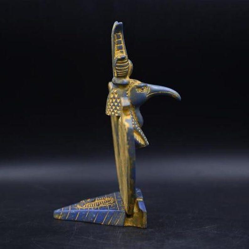 statue of the ancient Egyptian god Thoth with ibis head and upright pharaonic posture.