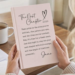 May include: A light pink hardback journal featuring the black text The Next Chapter 2026, a heart icon, and a printed quote: Take pride in the story you've written, the person you are, and the lives you've touched. Now, it's time for a fresh start.