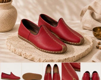 May include: A pair of red leather slip-on shoes featuring a textured grain finish, a rounded toe, and a decorative tan stitched seam running along the center of the vamp. The shoes have a low-profile design with a flat, tan-colored rubber sole.