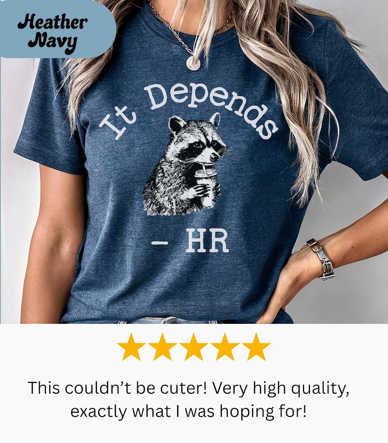 May include: Heather Navy t-shirt with the text "It Depends" and a raccoon graphic holding a drink. Below the graphic is "- HR". The shirt is a dark blue color.