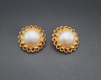 Pendientes de clip de perla con diseño floral en tono dorado, elegantes y llamativos.