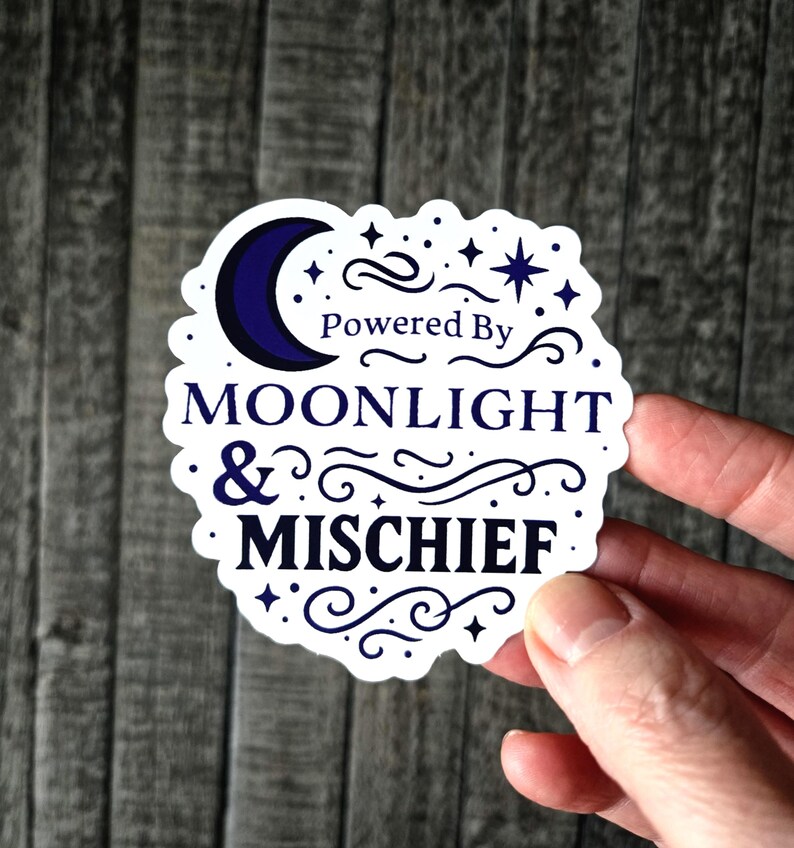 Enchanting "Powered by Moonlight & Mischief" vinyl sticker. This mystical sticker features a gorgeous crescent moon surrounded by twinkling stars and celestial flourishes in dreamy purple hues - perfect for night owls, lunar lovers, and witchy souls who do their best work when the sun goes down.