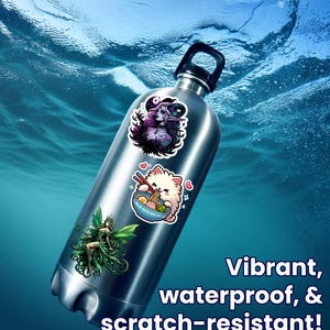 May include: A stainless steel water bottle with three colorful stickers. The stickers feature a fairy, a cat eating ramen, and a woman with horns. The text on the image reads: "Vibrant, waterproof, & scratch-resistant!"